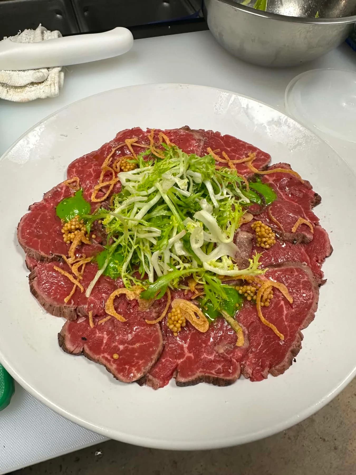 Sliced meat plated during Sigi's hotel training in Spain.